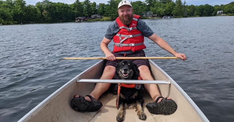 man in a canoe with a dog | Is It Safe to Canoe With a Dog?