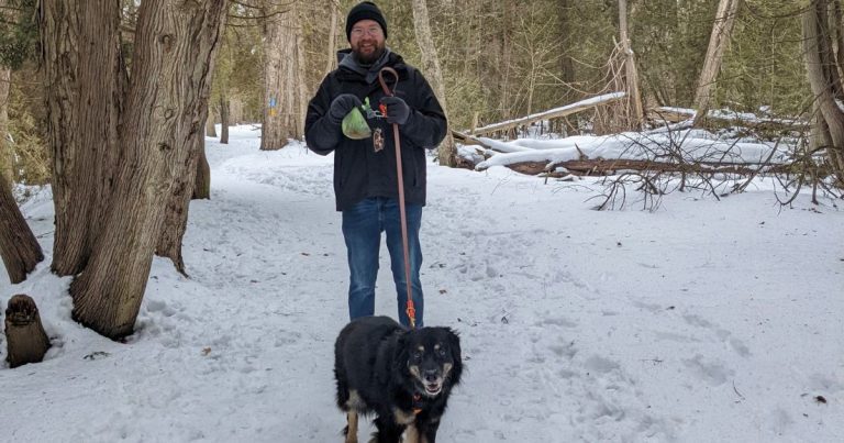 man walking dog holding a dog poop bag | What Do You Do With Dog Poop While Hiking?