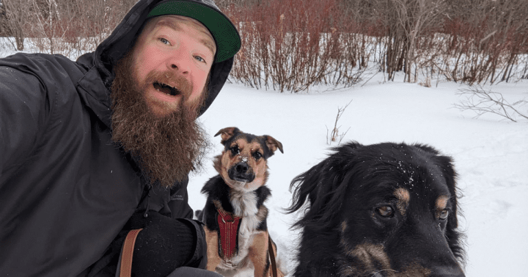 man outside in the snow with 2 dogs | Kick Off 2024 with a First Day Hike