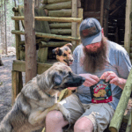 a man opening a bag of dog treats for two dogs | Tested & Trusted: The Canadian Pet and Outdoor Brands That Make Our Trips Possible
